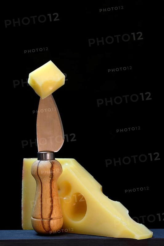A piece of Swiss Emmental cheese on a cheese knife