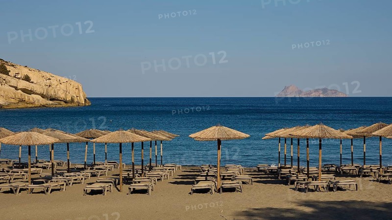 Paximadia island, quiet beach with umbrellas and deckchairs, view of a distant island, Matala, south coast, Crete, Greek Islands, Greece