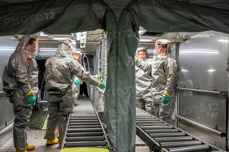 Decontamination of injured persons after an assumed accident involving hazardous substances, fire brigade and aid organisations practise setting up and operating a decontamination station, injured persons are sighted and then washed in a special shower tent to remove possible hazardous substances and chemicals in order to avoid further injuries, the emergency services wear special, ventilated protective suits, large-scale exercise by the Essen fire brigade