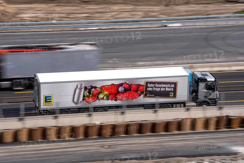 Freight truck for food logistics, on the motorway, supermarket chain EDEKA