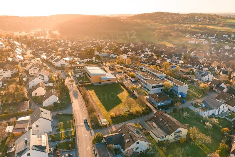 Urban suburbs seen from the air with buildings and roads at sunset, Schlehengäuschule, Gechingen, Hecken and Gäu region, Calw district, Germany