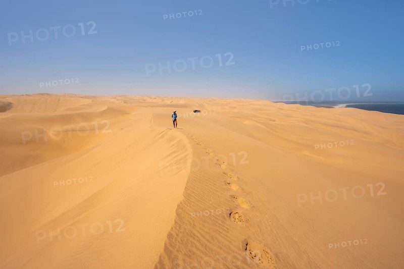 Lonely people between sand dunes with wave patterns, dune sea, sandy desert, impressive desert landscape, Namib Naukluft Park, Namib Desert, Namibia