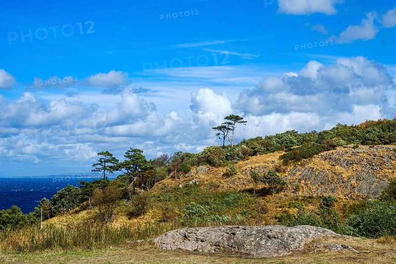 Standing rock against a blurred coastal landscape, Kullaberg near Mölle in Scania, Sweden. Outcropping Rock against a Blurred Coastal Landscape Receding into the Background, Kullaberg near Mölle in Scania, Sweden