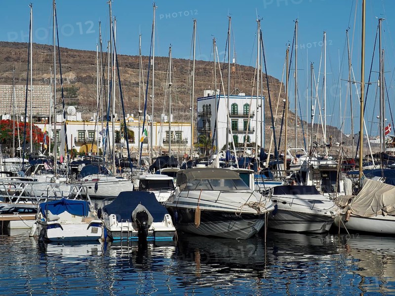 Full harbor with yachts and masts in the foreground and mountains in the background, Puerto de Mogan, Gran Canaria, Spain