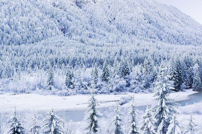 Isar valley in winter at temperatures of minus 18 degrees Celsius. Snow covered landscape with the Isar river flowing through. Some hoar frosted trees. Early morning