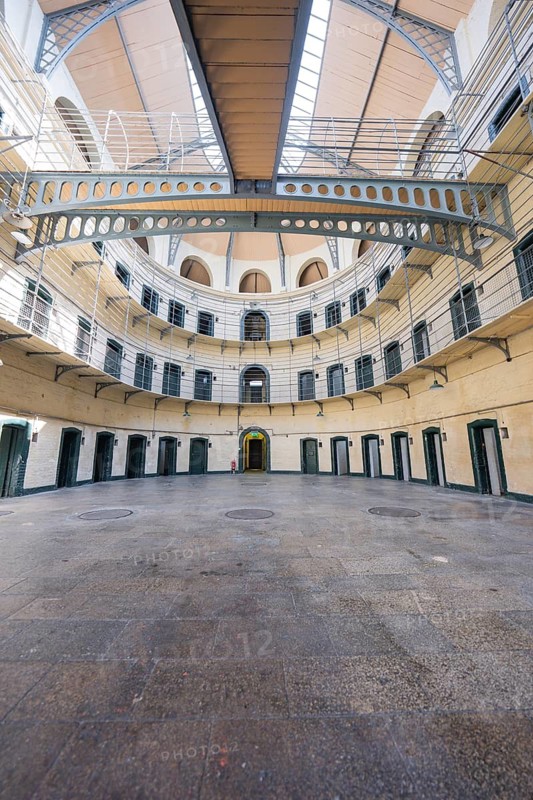 Expansive view of the ground floor of a round prison with multiple cells and doors, Kilmainham Gaol Prison, Dublin, Ireland