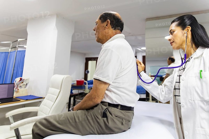 A doctor is using a stethoscope to examine a patient in a Latin hospital, highlighting the importance of medical care and physician-patient interaction in a clinical setting