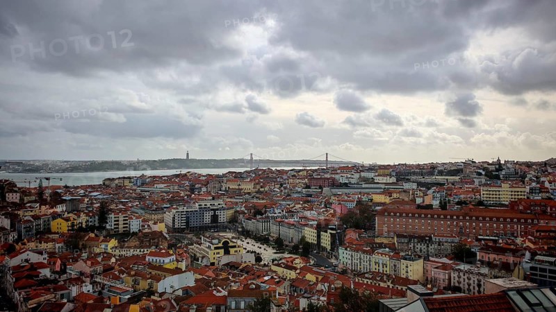 Wide view of Lisbon with river and dark clouds in the sky, Miradouro da Senhora do Monte McMlxii viewpoint, Lisbon, Portugal