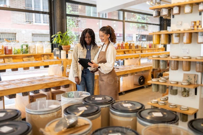 A helpful clerk assists a customer in an organic bulk store, surrounded by natural products and eco-friendly packaging, promoting a sustainable lifestyle and mindful shopping