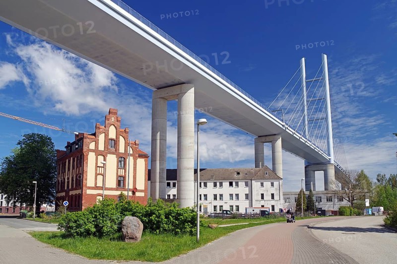 Modern bridge spanning the road surrounded by historic buildings and clear skies, Rügen Bridge, Stralsund, Mecklenburg-Western Pomerania, Germany