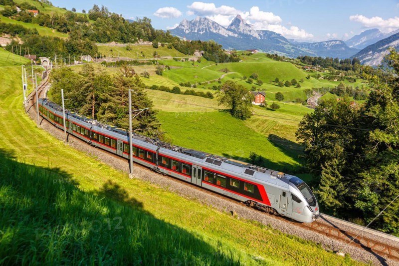 Railway passenger train of the type Stadler Flirt of the Südostbahn on the mountain Großer Mythen in the Alps in Arth, Switzerland
