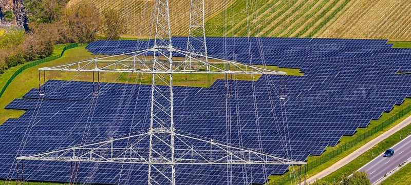 Open-space photovoltaic system, solar park in Talheim am Neckar. high voltage line. aerial view. Baden-Württemberg, Germany