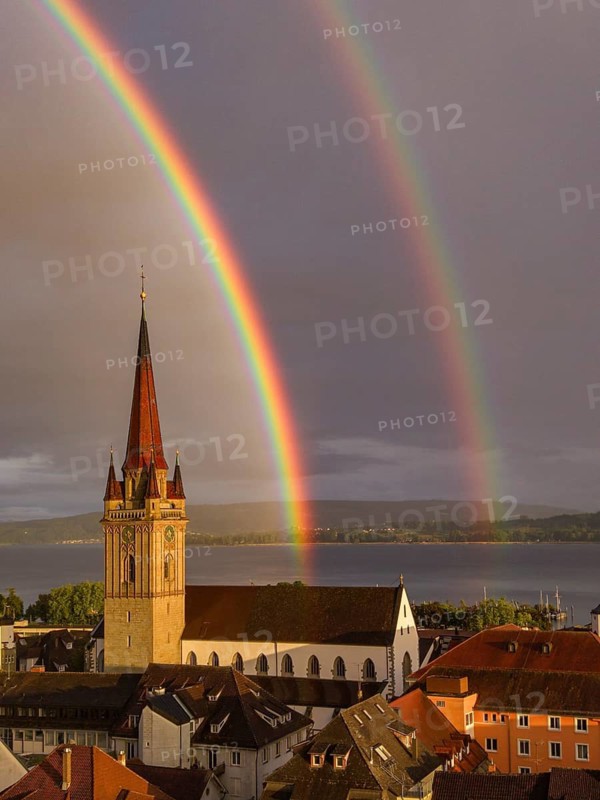 Aerial view of the historic old town of Radolfzell am Lake Constance with the cathedral illuminated by the evening sun, behind it a rainbow, district of Konstanz, Baden-Württemberg, Germany