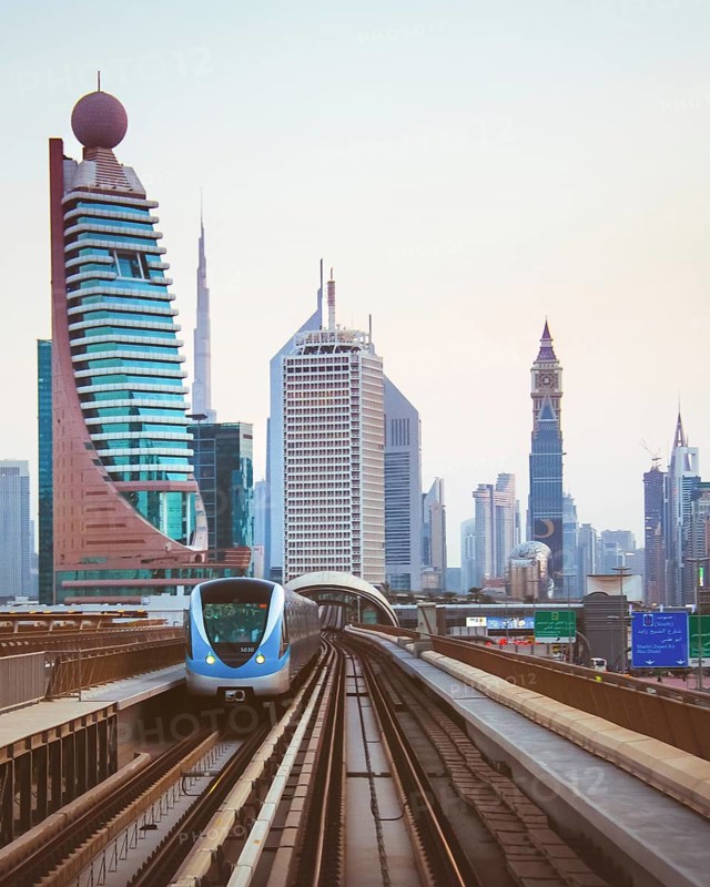 Dubai, UAE - 10th october, 2022: Driverless Dubai Metro train speeding along elevated tracks on Sheikh Zayed Road with the city skyline—including Burj Khalifa and landmark towers—in the background