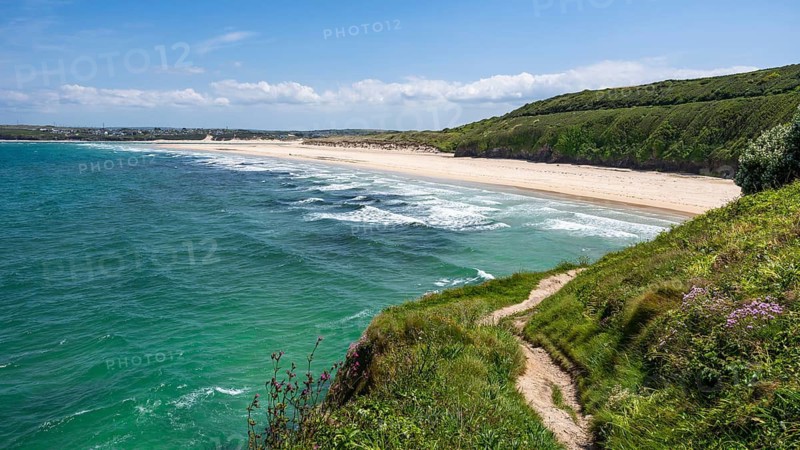 View of Porthkidney Beach. A footpath in the foreground. sandy beach beach, sea, landscape. Good weather, blue sky. Porthkidney Beach, Hayle, West Cornwall, England, Great Britain