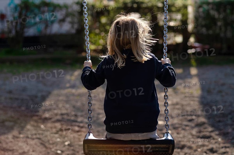 Girl, 4 years, blonde, swinging on swing, from behind, public playground, urban, Stuttgart, Baden-Württemberg, Germany