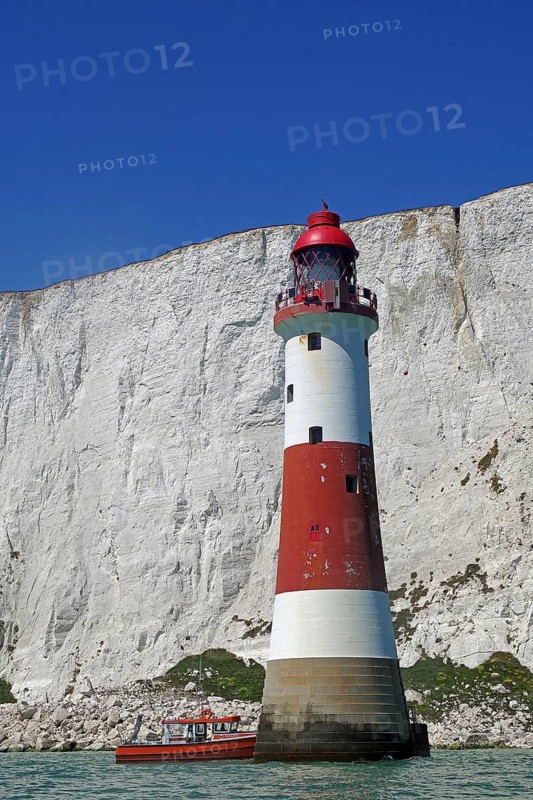 Red and white lighthouse in front of majestic white cliffs and blue sky by the sea, sight, Beachy Head Lighthouse, Beachy Head Cliffs, English Channel, Eastbourne, Sussex, England, United Kingdom