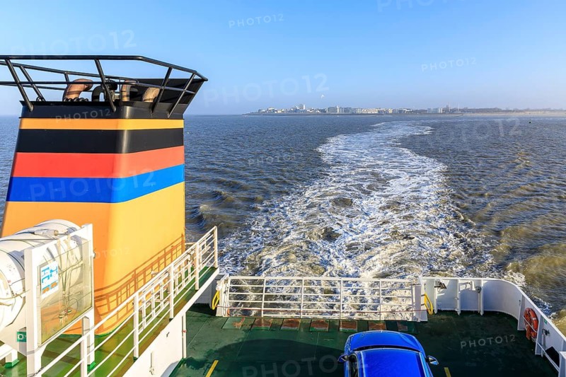 Ferry Frisia II crossing from Norderney to Norddeich Mole, in the background the silhouette of Norderney, Lower Saxony, Germany
