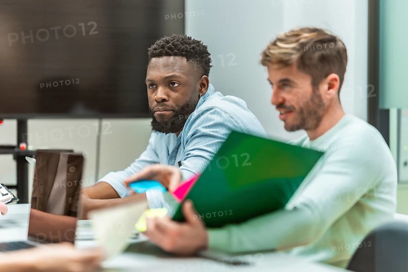Office workers collaborating on a project, sharing ideas and documents in a productive work environment