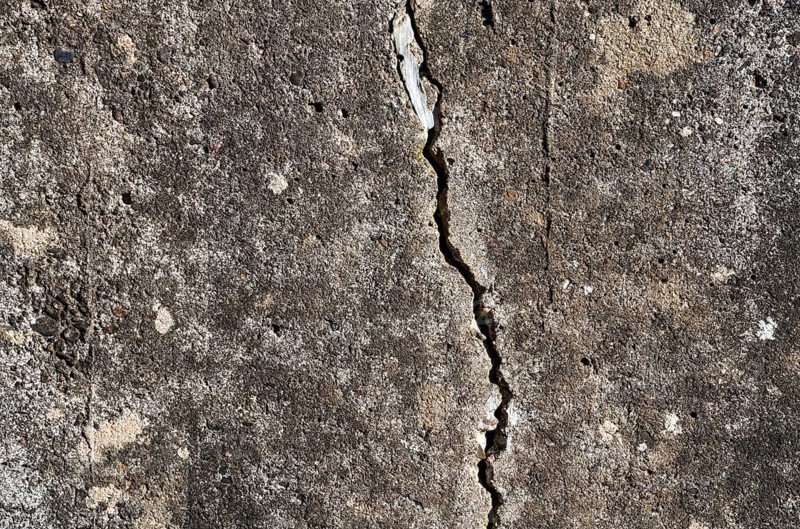 Old concrete wall with cracks, structures and green moss