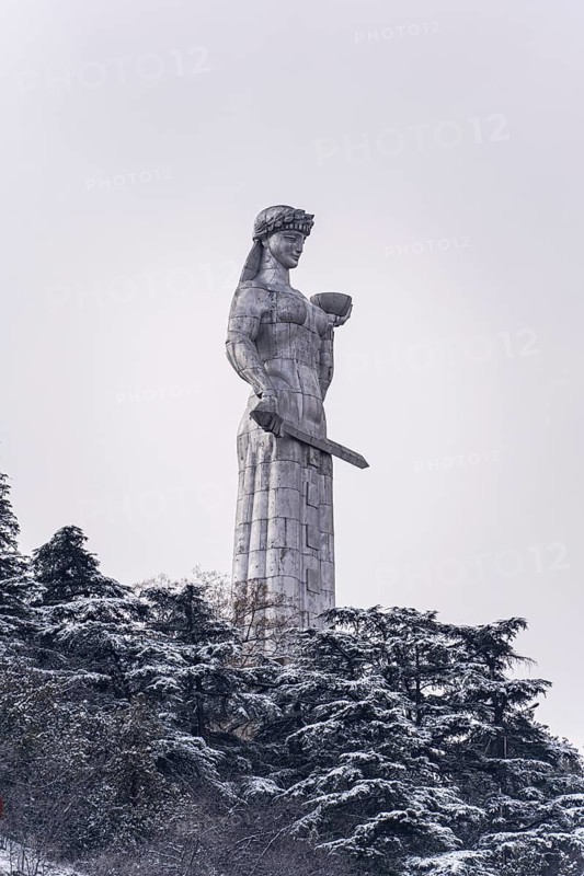 Majestic Mother of Georgia Statue amidst snow-covered trees in Tbilisi's historic center, capturing the serene beauty and cultural essence of Georgia's capital in winter