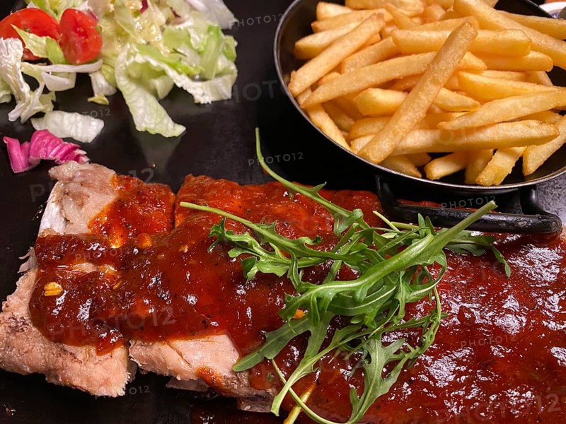 Portion of spare ribs, pork ribs, with barbecue sauce, french fries, salad, on plate, garnished with arugula, food, Stuttgart, Baden-Württemberg, Germany