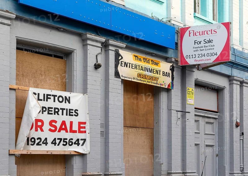 Fleurets pub estate agency For Sale sign on boarded up bar premises, Grimsby, north east Lincolnshire, England, UK