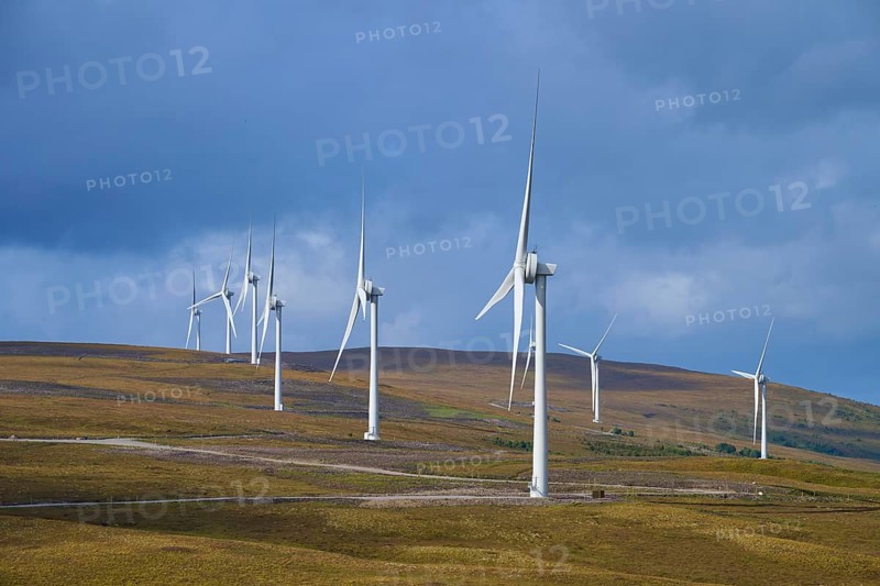 Row of wind turbines on hills under blue sky with some clouds, Lairg, Scotland, United Kingdom, United Kingdom