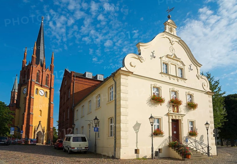 View of a church tower and a baroque building with a paved forecourt in sunny weather, Heilig-Geist-Kirche and town hall, old town island of Werder in der Havel, Potsdam-Mittelmark, Brandenburg, Germany