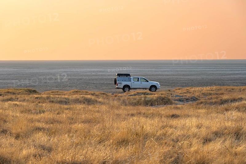 Off-road vehicle on the salt pan, at sunrise, Kubu Island (Lekubu), Sowa Pan, Makgadikgadi salt pans, Botswana