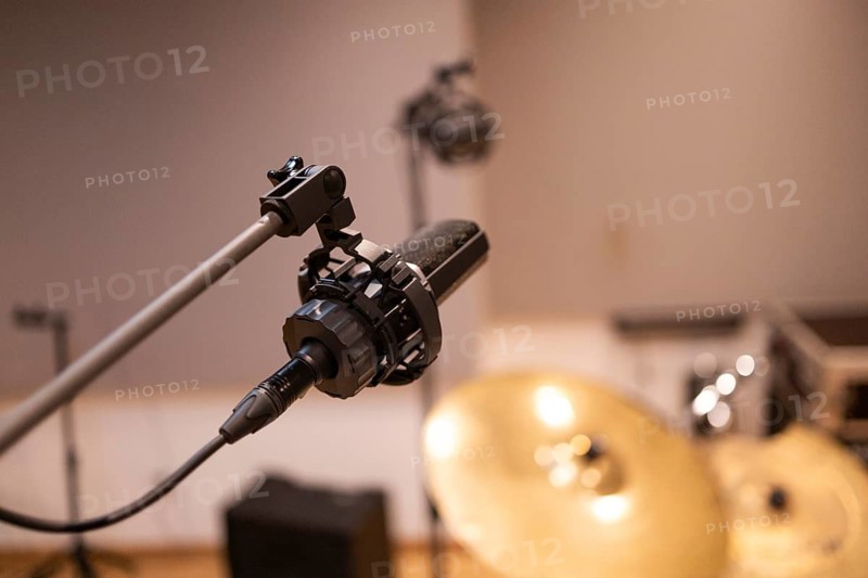 Close-up of a professional microphone in a recording studio, focusing on audio equipment for music production. Ideal for sound, music, and technology projects