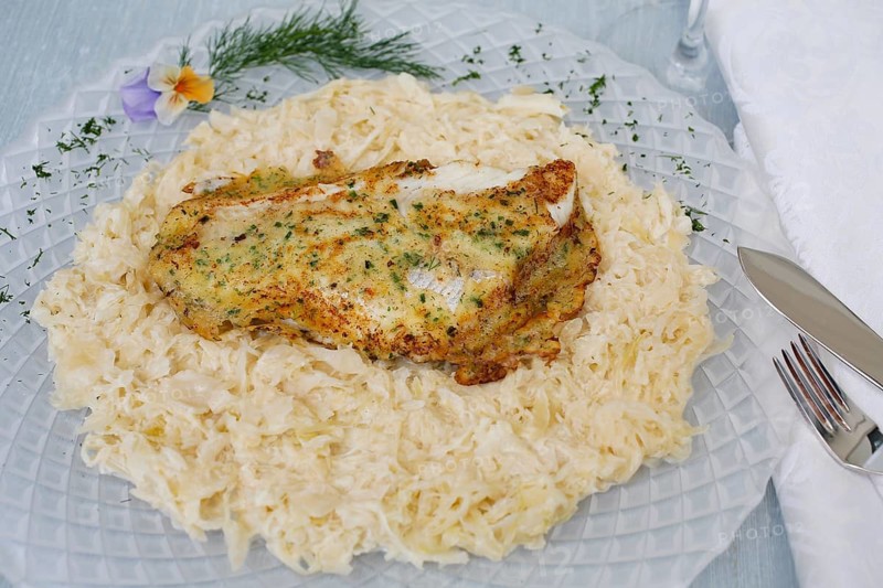 Swabian cuisine, fillet of Lake Constance whitefish with herbs and creamed cabbage, sauerkraut, fish dish, freshwater fish, served on a plate, dill, flowers, fish cutlery, typical Swabian cuisine, traditional cuisine reinterpreted, food photography, studio, Germany