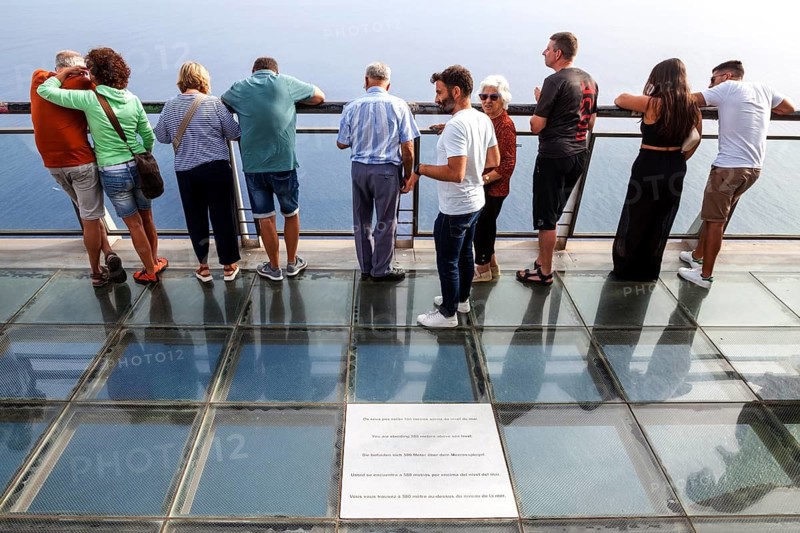 Tourists enjoy the view from the glass-bottom skywalk, Cabo Girao, Camara de Lobos, Madeira Island, Portugal