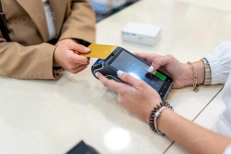 Customer paying for products using a credit card on a payment terminal, demonstrating modern retail transactions and convenient shopping in a healthcare setting