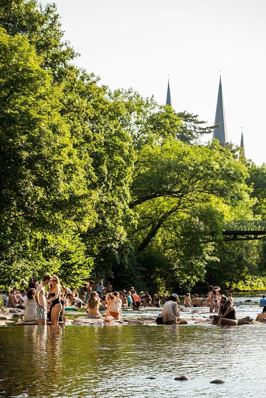 Young people sitting by and in the river, bathing in the city, heat, heat wave, climate change, Dreisam, Freiburg im Breisgau, Black Forest, Baden-Württemberg, southern Germany, Germany