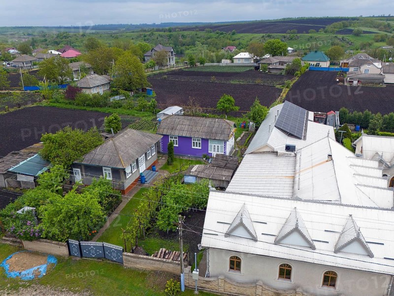 Overview of a rural settlement with solar panels on a large roof and small houses, contrasting rich and poor, aerial view, Caracusenii Vechi, Caracu?enii Vechi, North Region, Briceni District, Republic of Moldova, Moldova