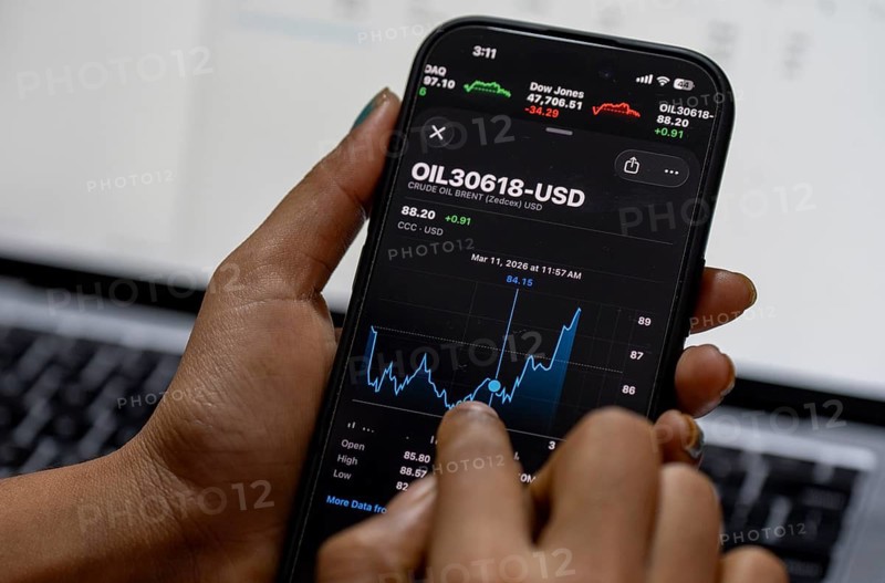 In this photo illustration, a person looks at a smartphone displaying Brent crude oil prices in USD, in Guwahati, India, on March 11, 2026. Oil prices reversed course from recent highs, slipping to around 90 USD a barrel after remarks by U.S. President Donald Trump on the Iran conflict. Markets remain unsettled as traders monitor the evolving geopolitical situation