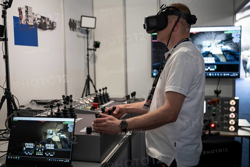 LUBIN, POLAND - JUNE 6, 2025: International Mining and Metallurgy Congress in Lubin.A man in VR glasses works on a mining machine simulator