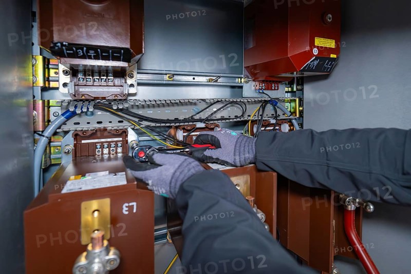 A technician works inside a switch box and uses tools for maintenance, switch cabinet construction, PV system construction, major customers, Enzkreis, Germany
