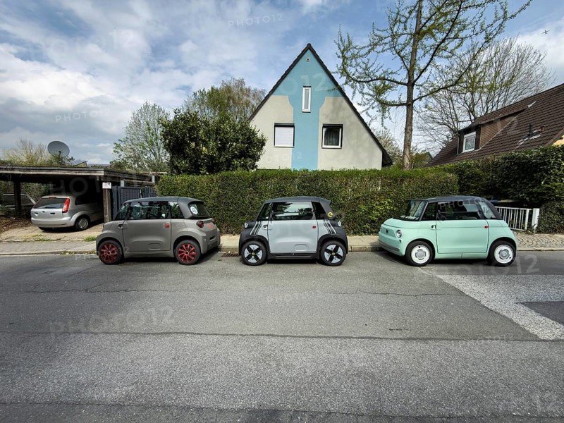 Three small electric cars park in a row in front of a single-family house in Essen, Germany