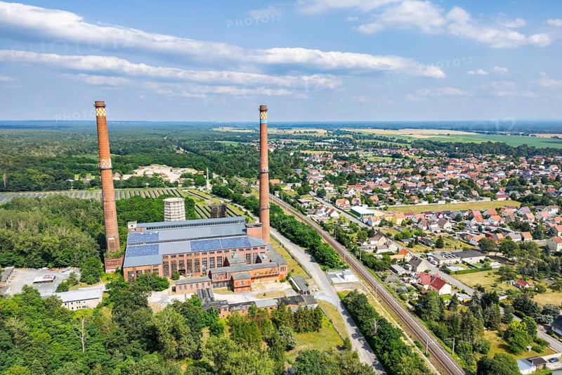 Aerial view, drone photo: Industrial monument decommissioned lignite-fired power plant Plessa with two chimneys, on the right the municipality of Plessa, Lusatia, Brandenburg, Germany