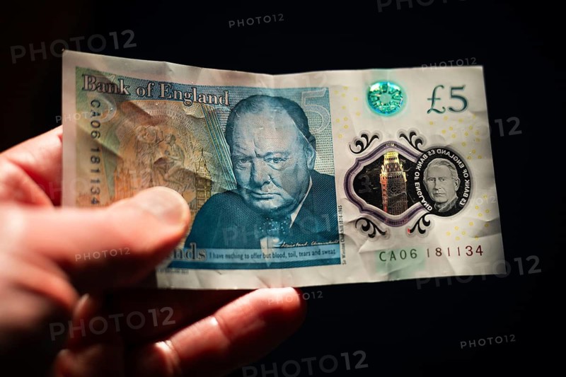 Close-up of a Bank of England five pound note featuring Sir Winston Churchill and the portrait of King Charles III