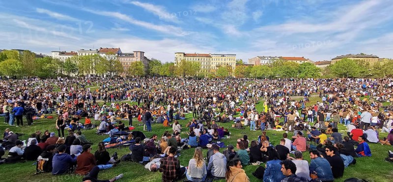 May 1, public holiday, Labor Day in Görlitzer Park in Berlin, many people sitting relaxing on the meadow under a blue sky, panorama, Berlin