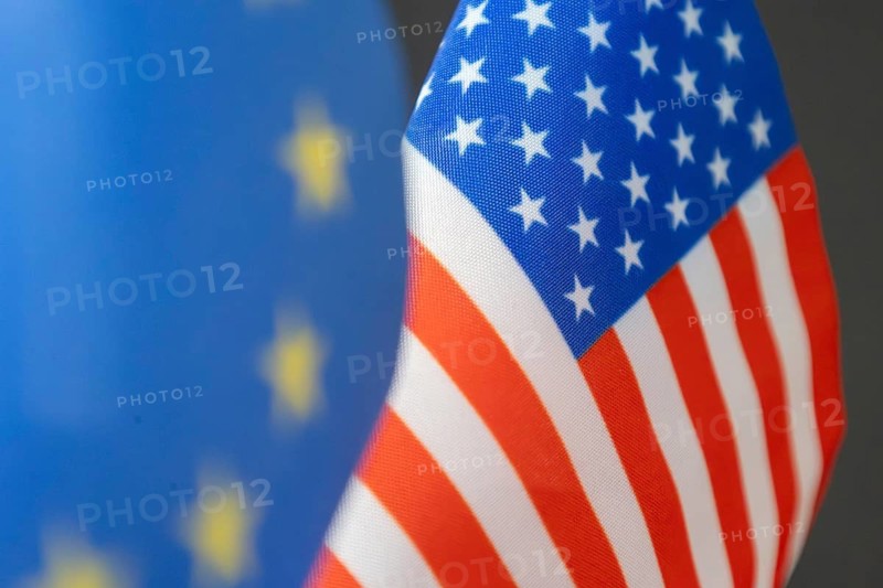 Flag of the USA, blurred in the foreground the flag of the European Union