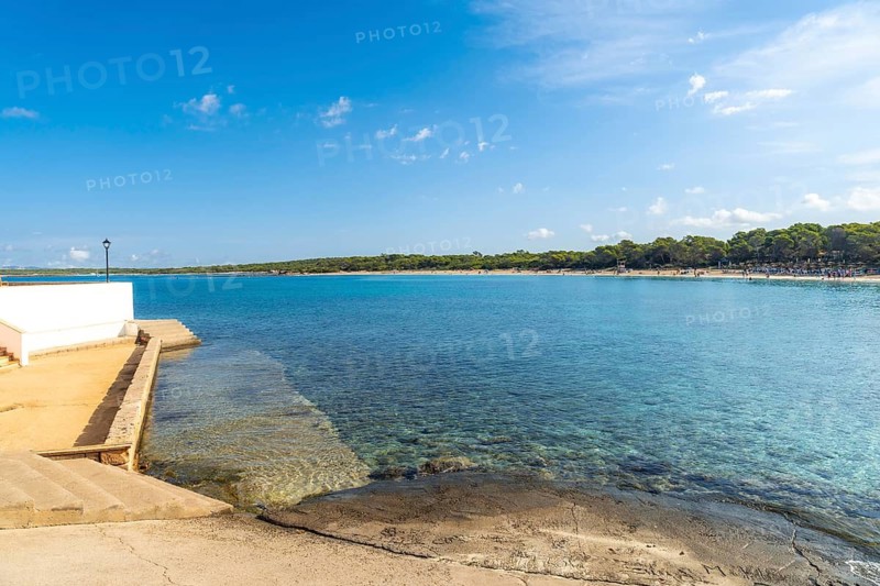 Turquoise shallow water meets white sand beach on the coast of mallorca island, spain, near colonia de sant jordi