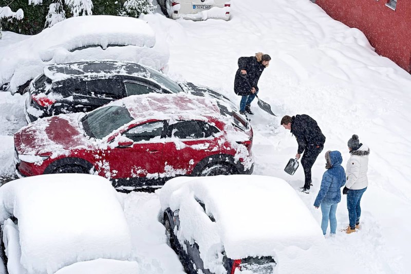 Man and woman shovelling snow on car park, car, car, snowed in, fresh snow, heavy snowfall, snow masses, snow chaos, snow shovel, onset of winter, Marzling, Freising, Upper Bavaria, Bavaria, Germany