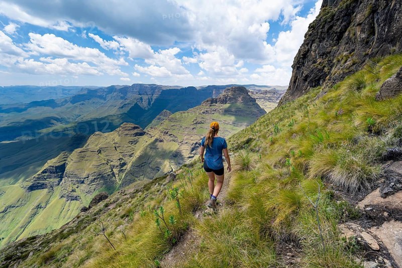 Female mountaineer hiking trail to Cathedral Peak or Cathedralpiek or Mponjwana, Drakensberg, KwaZulu-Natal, South Africa
