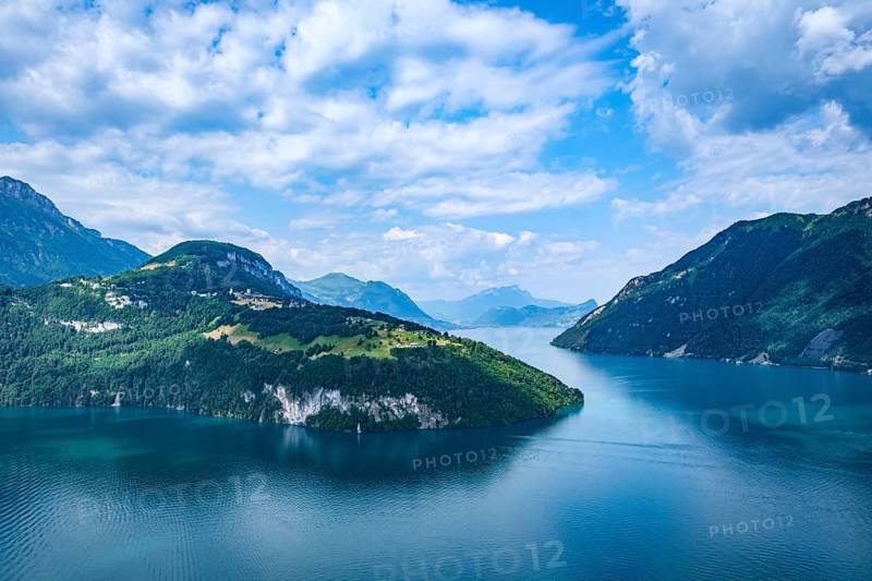 Idyllic mountain landscape with a calm lake under blue sky and clouds, Lake Lucerne, Brunnen, Canton of Schwyz, Switzerland