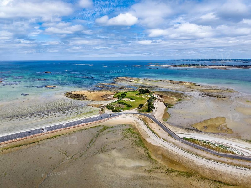 Aerial view of the peninsula, Îlot Sainte-Anne and the surrounding Wadden Sea landscape on the Breton coast with shallow sandbanks in turquoise seawater, Saint-Pol-de-Léon, Finistère, Brittany, France