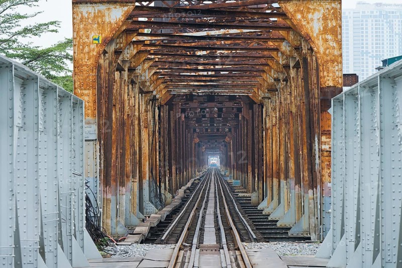 A train, locomotive, of the Vietnamese State Railways crosses the Long Bien railway bridge over the Red River, Hanoi, Ha Noi province, Vietnam
